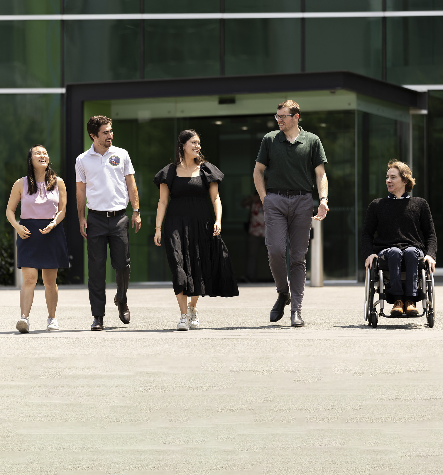 A team of diverse staff standing outside an office building.