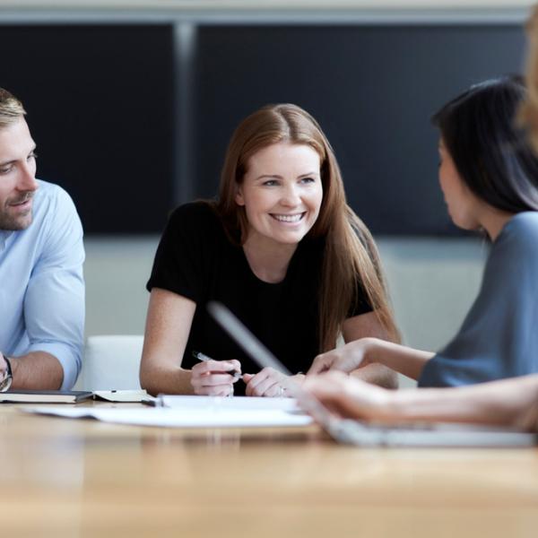 Smiling graduates talking in a meeting