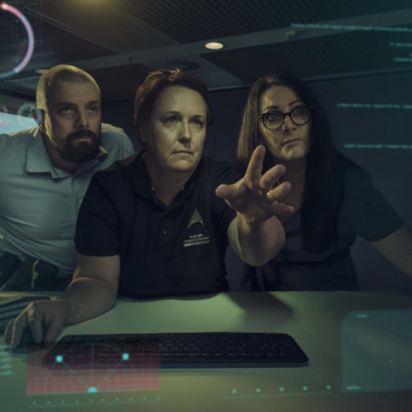 Three workers analysing data on a computer