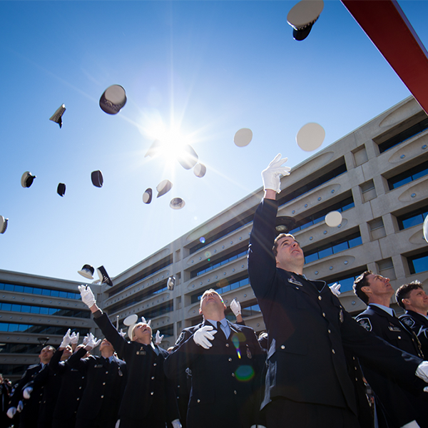 Graduates celebrating and throwing their caps in the air