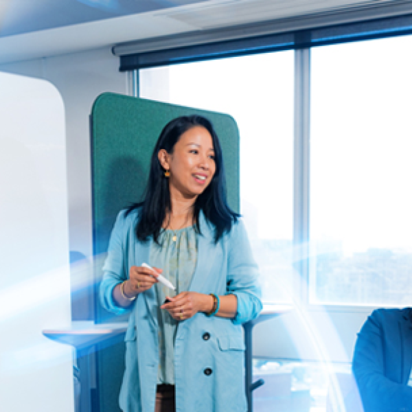 Professional presenting to colleagues at a whiteboard