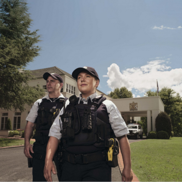 Two uniformed police officers walking in public space